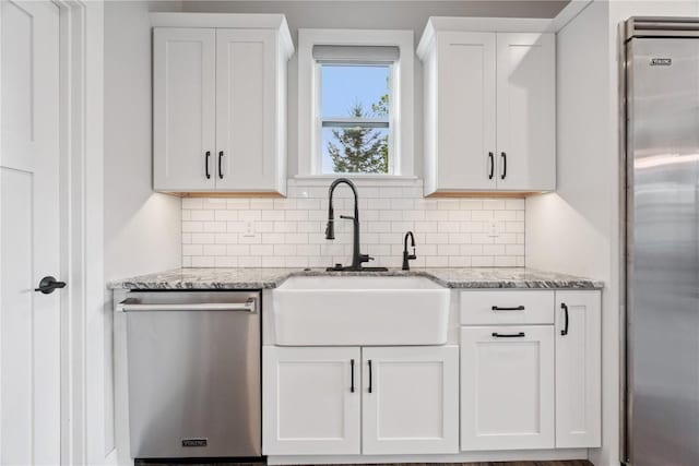 4395 Rec Dr, Marion, IA 52302 - kitchen featuring appliances with stainless steel finishes, tasteful backsplash, white cabinets, and light stone counters