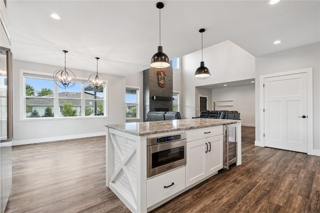4395 Rec Dr, Marion, IA 52302 - kitchen featuring beverage cooler, open floor plan, dark wood finished floors, white cabinets, and a center island