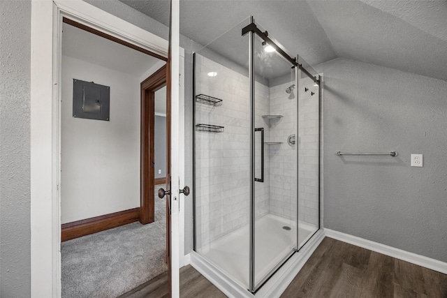 308 Main St, Norway, IA 52318 - bathroom with electric panel, a stall shower, wood finished floors, vaulted ceiling, and a textured ceiling