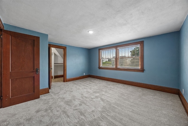 308 Main St, Norway, IA 52318 - unfurnished bedroom featuring carpet, a textured ceiling, a walk in closet, and a closet