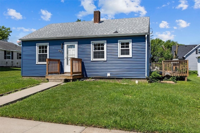 107 Spruce St, Blairstown, IA 52209 - bungalow with a chimney, a front yard, a shingled roof, and a deck