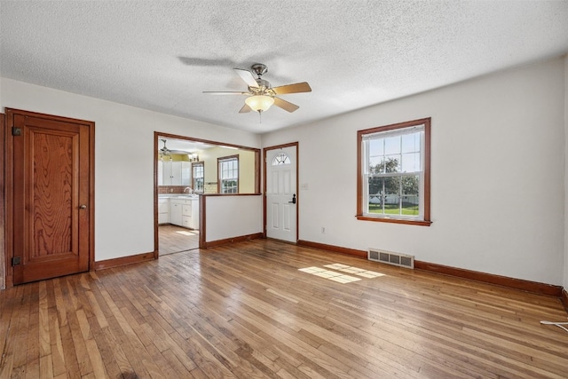 107 Spruce St, Blairstown, IA 52209 - unfurnished room featuring a ceiling fan, light wood-style flooring, and a textured ceiling