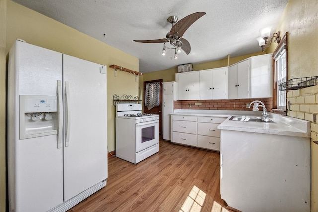 107 Spruce St, Blairstown, IA 52209 - kitchen featuring white appliances, light countertops, white cabinets, ceiling fan, and light wood finished floors