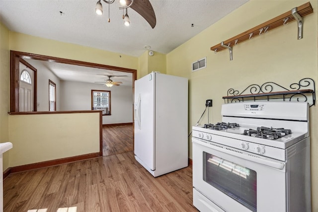 107 Spruce St, Blairstown, IA 52209 - kitchen with white appliances, ceiling fan, light wood finished floors, and a textured ceiling