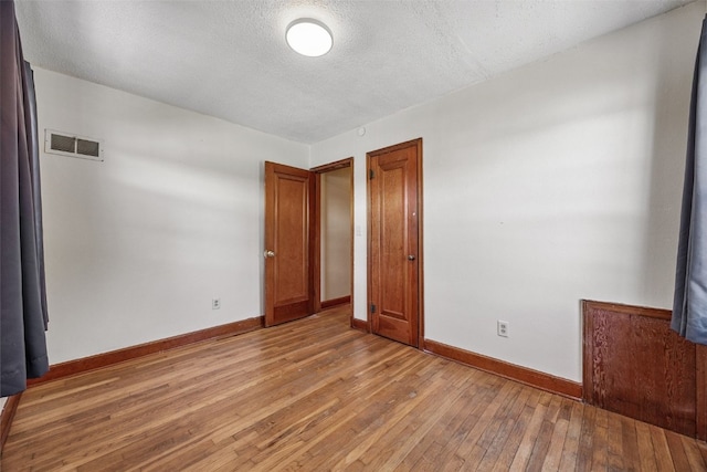 107 Spruce St, Blairstown, IA 52209 - empty room featuring light wood finished floors and a textured ceiling