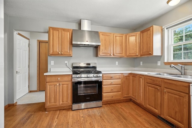 965 Hampshire Dr, Marion, IA 52328 - kitchen with stainless steel range with gas cooktop, wall chimney range hood, light wood-style flooring, and light countertops