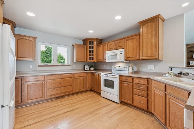 405 Linn Dr, Palo, IA 52324 - kitchen with white appliances, light wood-style flooring, light countertops, recessed lighting, and glass insert cabinets