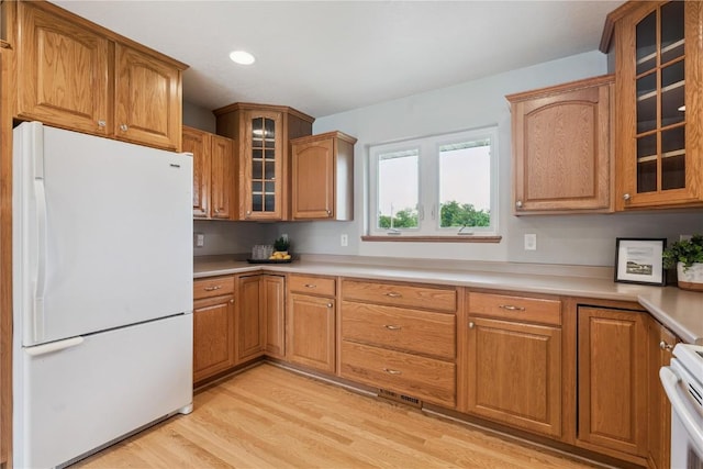 405 Linn Dr, Palo, IA 52324 - kitchen with freestanding refrigerator, light wood-type flooring, glass insert cabinets, light countertops, and range