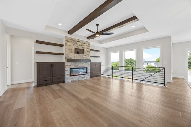 4018 Peridot Dr, Marion, IA 52302 - unfurnished living room featuring a ceiling fan, light wood-style floors, a tray ceiling, a fireplace, and beam ceiling