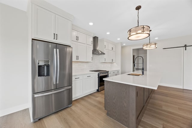 4018 Peridot Dr, Marion, IA 52302 - kitchen featuring appliances with stainless steel finishes, wall chimney range hood, a barn door, white cabinetry, and tasteful backsplash