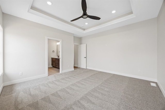 4018 Peridot Dr, Marion, IA 52302 - unfurnished bedroom featuring a tray ceiling, light colored carpet, recessed lighting, and ensuite bathroom
