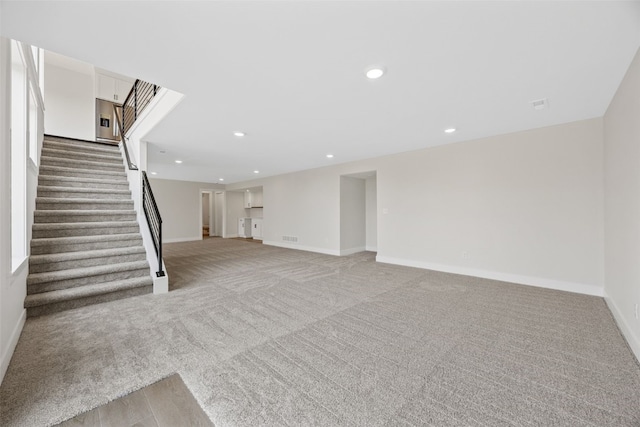4018 Peridot Dr, Marion, IA 52302 - unfurnished living room featuring light colored carpet, stairs, and recessed lighting