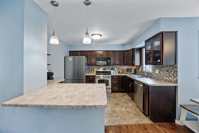 1608 10th St, Coralville, IA 52241 - kitchen with appliances with stainless steel finishes, dark brown cabinets, backsplash, and light countertops