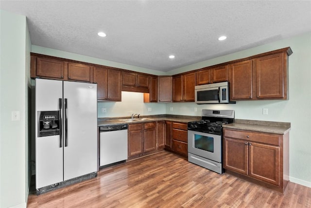 3107 Johnson Ave NW Unit 4, Cedar Rapids, IA 52405 - kitchen featuring stainless steel appliances, dark countertops, light wood-style flooring, recessed lighting, and a textured ceiling