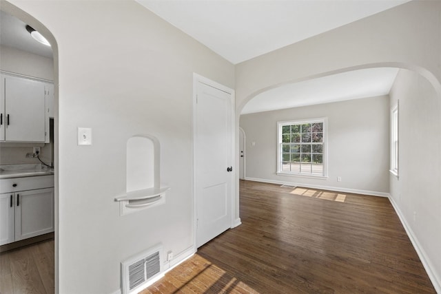 2225 SE Mount Vernon Rd, Cedar Rapids, IA 52403 - empty room with arched walkways and dark wood-type flooring