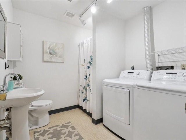 2007 S Ridge Dr, Coralville, IA 52241 - laundry area featuring washing machine and clothes dryer and rail lighting