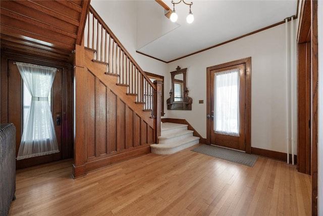 103 10th Ave SW, Mount Vernon, IA 52314 - entrance foyer featuring stairs, radiator, light wood-type flooring, and ornamental molding