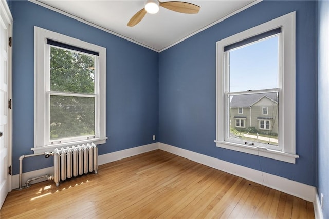 103 10th Ave SW, Mount Vernon, IA 52314 - spare room featuring radiator, light wood-style flooring, ceiling fan, and ornamental molding
