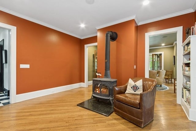 404 Brown St, Iowa City, IA 52245 - living area featuring a wood stove, light wood-style floors, crown molding, and recessed lighting