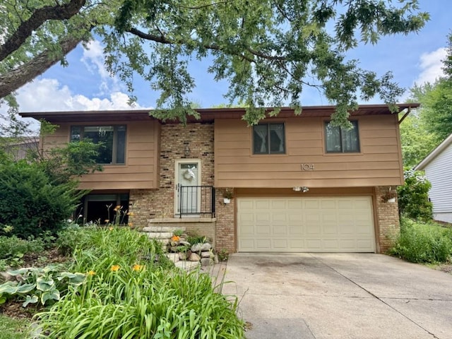 104 Oberlin St, Iowa City, IA 52245 - bi-level home with brick siding, an attached garage, and driveway