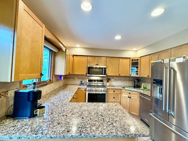 104 Oberlin St, Iowa City, IA 52245 - kitchen with appliances with stainless steel finishes, light stone counters, glass insert cabinets, and recessed lighting