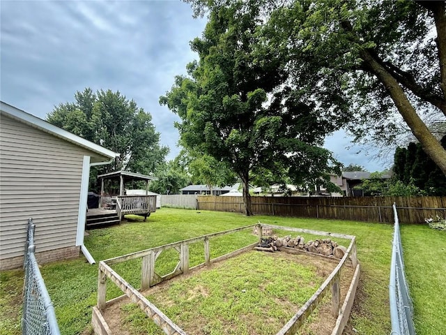 507 Maplewood Dr, Center Point, IA 52213 - fenced backyard featuring a deck and a vegetable garden