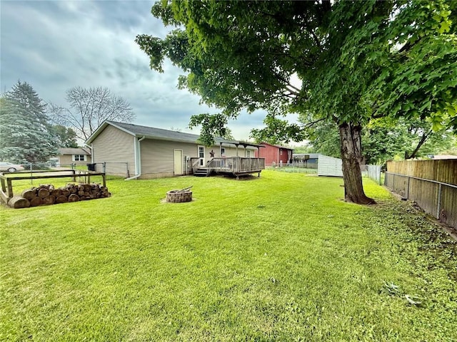 507 Maplewood Dr, Center Point, IA 52213 - fenced backyard with a fire pit, a deck, and a storage unit
