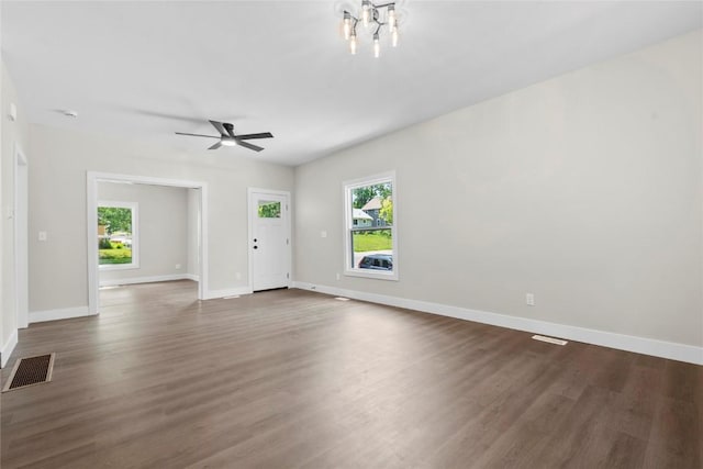 1356 Hinkley Ave NW, Cedar Rapids, IA 52405 - unfurnished living room featuring healthy amount of natural light, dark wood-type flooring, and a ceiling fan
