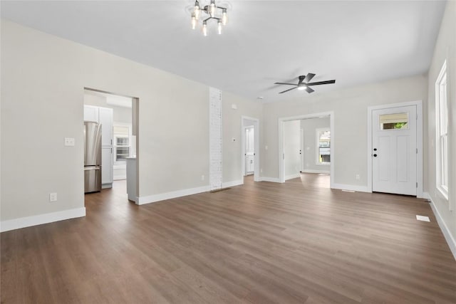 1356 Hinkley Ave NW, Cedar Rapids, IA 52405 - unfurnished living room featuring dark wood-style flooring, a ceiling fan, and a chandelier