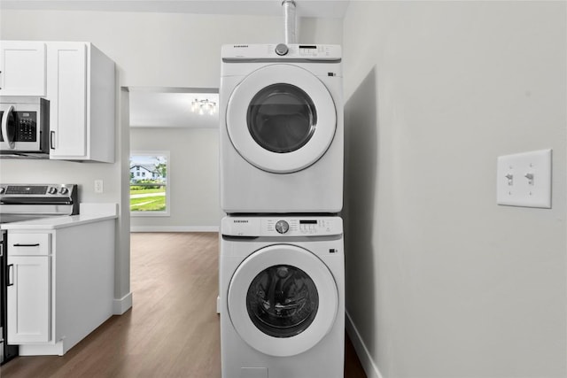 1356 Hinkley Ave NW, Cedar Rapids, IA 52405 - washroom featuring estacked washer and dryer and wood finished floors