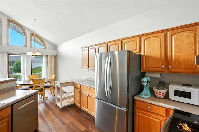 1459 Buckingham Ln, Iowa City, IA 52245 - kitchen with stainless steel appliances, vaulted ceiling, dark wood-type flooring, light countertops, and a textured ceiling