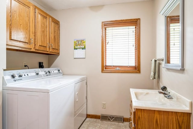1595 17th Ave, Marion, IA 52302 - washroom featuring cabinet space, washing machine and dryer, and light tile patterned flooring