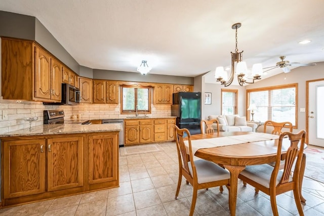 1595 17th Ave, Marion, IA 52302 - dining area featuring a chandelier, ceiling fan, vaulted ceiling, and light tile patterned floors