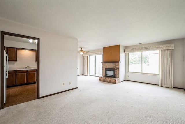 809 Kerry Ln SE Unit 66, Cedar Rapids, IA 52403 - unfurnished living room featuring light carpet, a fireplace, ceiling fan, and a textured ceiling