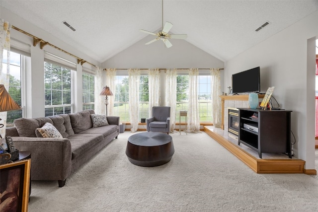 4710 Westchester Dr NE Unit C, Cedar Rapids, IA 52402 - carpeted living room with ceiling fan, lofted ceiling, plenty of natural light, a tile fireplace, and a textured ceiling