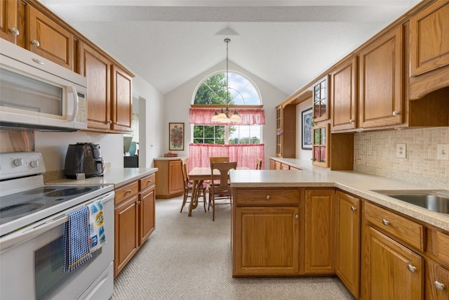 4710 Westchester Dr NE Unit C, Cedar Rapids, IA 52402 - kitchen featuring white appliances, brown cabinets, lofted ceiling, and light countertops