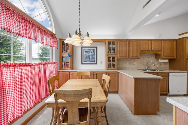 4710 Westchester Dr NE Unit C, Cedar Rapids, IA 52402 - kitchen featuring white dishwasher, light countertops, brown cabinetry, high vaulted ceiling, and glass insert cabinets