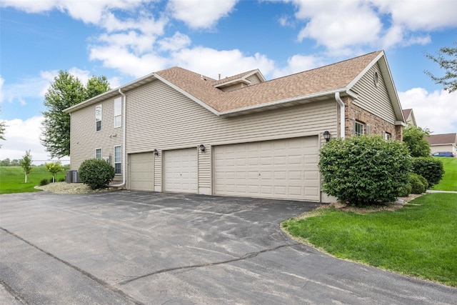 4710 Westchester Dr NE Unit C, Cedar Rapids, IA 52402 - view of side of home with driveway, roof with shingles, and an attached garage