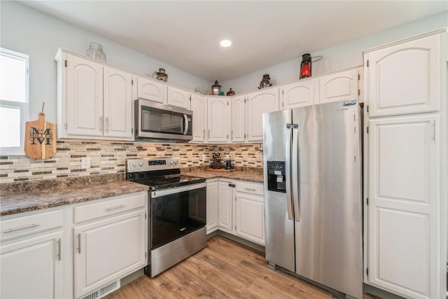 111 Maple St, Luzerne, IA 52257 - kitchen featuring appliances with stainless steel finishes, white cabinetry, backsplash, light wood-type flooring, and recessed lighting
