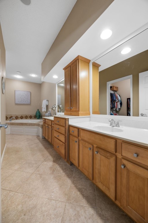 422 Rock Ridge Rd NW, Cedar Rapids, IA 52405 - bathroom with double vanity, tile patterned flooring, recessed lighting, and a walk in closet