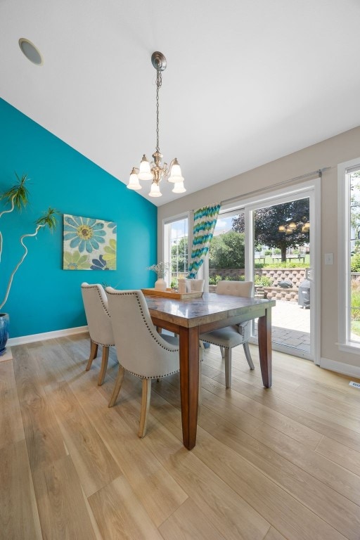 422 Rock Ridge Rd NW, Cedar Rapids, IA 52405 - dining room featuring a chandelier, light wood-style flooring, and vaulted ceiling