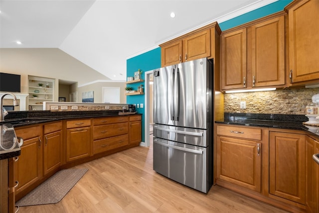 422 Rock Ridge Rd NW, Cedar Rapids, IA 52405 - kitchen with freestanding refrigerator, lofted ceiling, brown cabinetry, tasteful backsplash, and light wood-type flooring