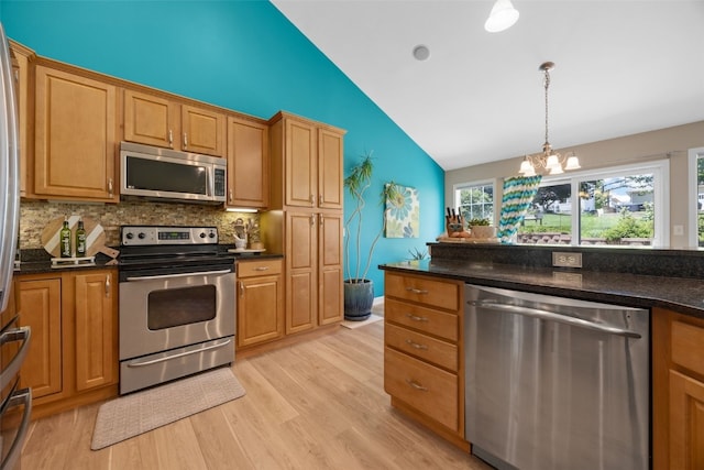 422 Rock Ridge Rd NW, Cedar Rapids, IA 52405 - kitchen with stainless steel appliances, decorative backsplash, light wood finished floors, a chandelier, and decorative light fixtures