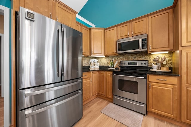 422 Rock Ridge Rd NW, Cedar Rapids, IA 52405 - kitchen featuring appliances with stainless steel finishes, backsplash, light wood-style floors, dark stone countertops, and brown cabinetry