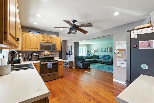 2113 Ridgewood Ave, Muscatine, IA 52761 - kitchen with appliances with stainless steel finishes, ceiling fan, light countertops, light wood finished floors, and recessed lighting