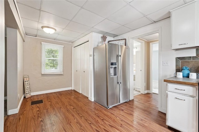 100 W Short St, Solon, IA 52333 - kitchen with high end fridge, a paneled ceiling, white cabinetry, and light wood-type flooring
