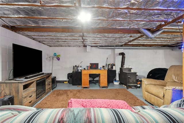 75 Jefferson Ave SW, Swisher, IA 52238 - living room with concrete flooring, a wood stove, and concrete block wall
