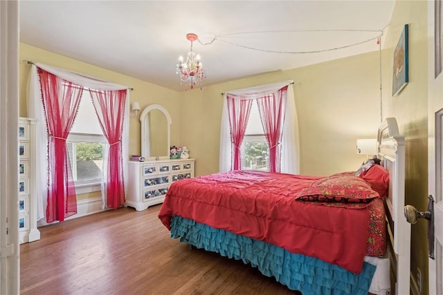 1727 Grande Ave SE, Cedar Rapids, IA 52403 - bedroom featuring multiple windows, wood finished floors, and a chandelier