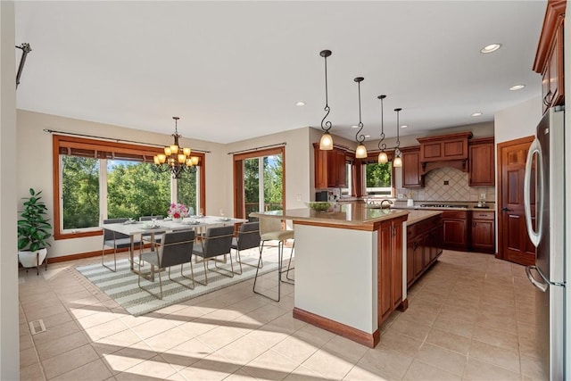 3037 Brookfield Dr, Marion, IA 52302 - kitchen featuring freestanding refrigerator, a chandelier, light countertops, backsplash, and stovetop