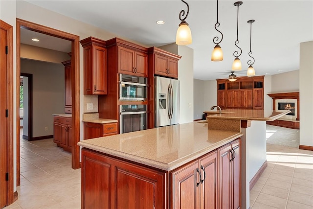 3037 Brookfield Dr, Marion, IA 52302 - kitchen featuring appliances with stainless steel finishes, light tile patterned floors, a ceiling fan, pendant lighting, and light stone countertops